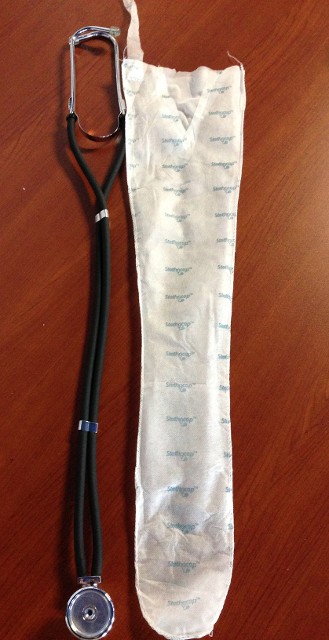 Pictured is a stethoscope next to a Stethocap Sleeve